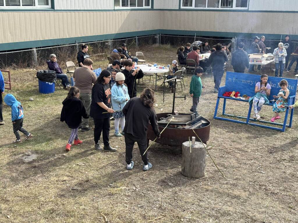 Students and adults at a cookout