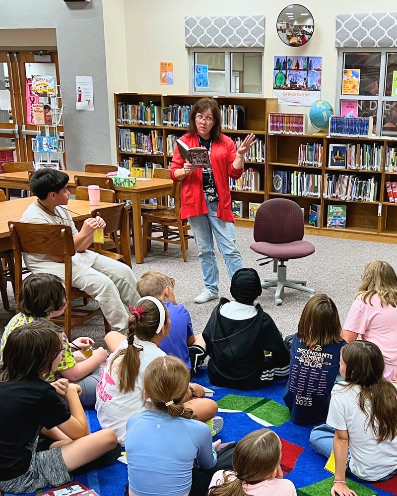 Teacher reading in the library to a class