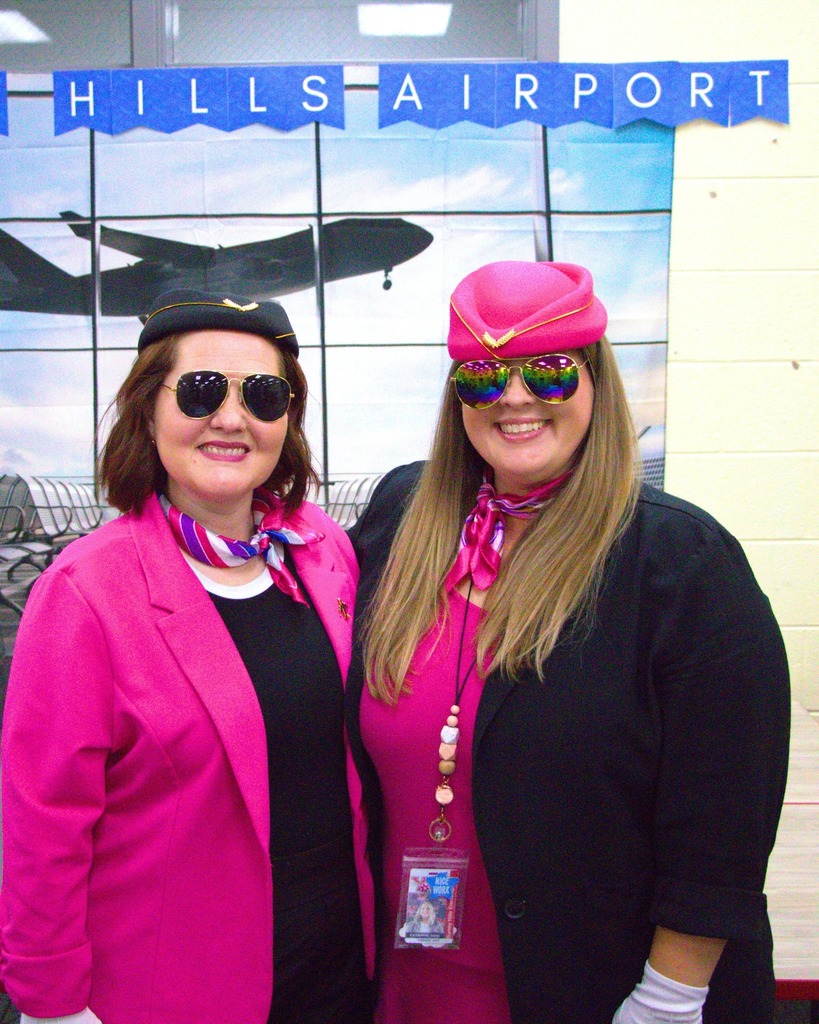 Two teachers smiling in flight attendant outfits