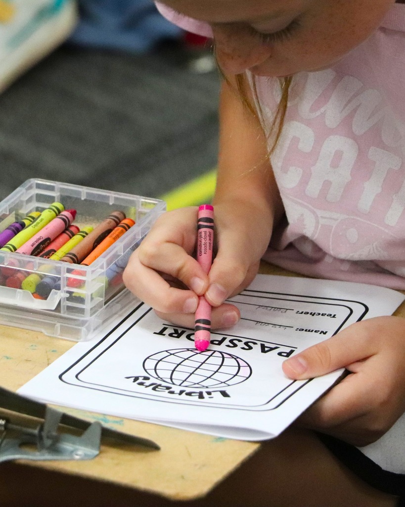 a girl coloring a piece of paper