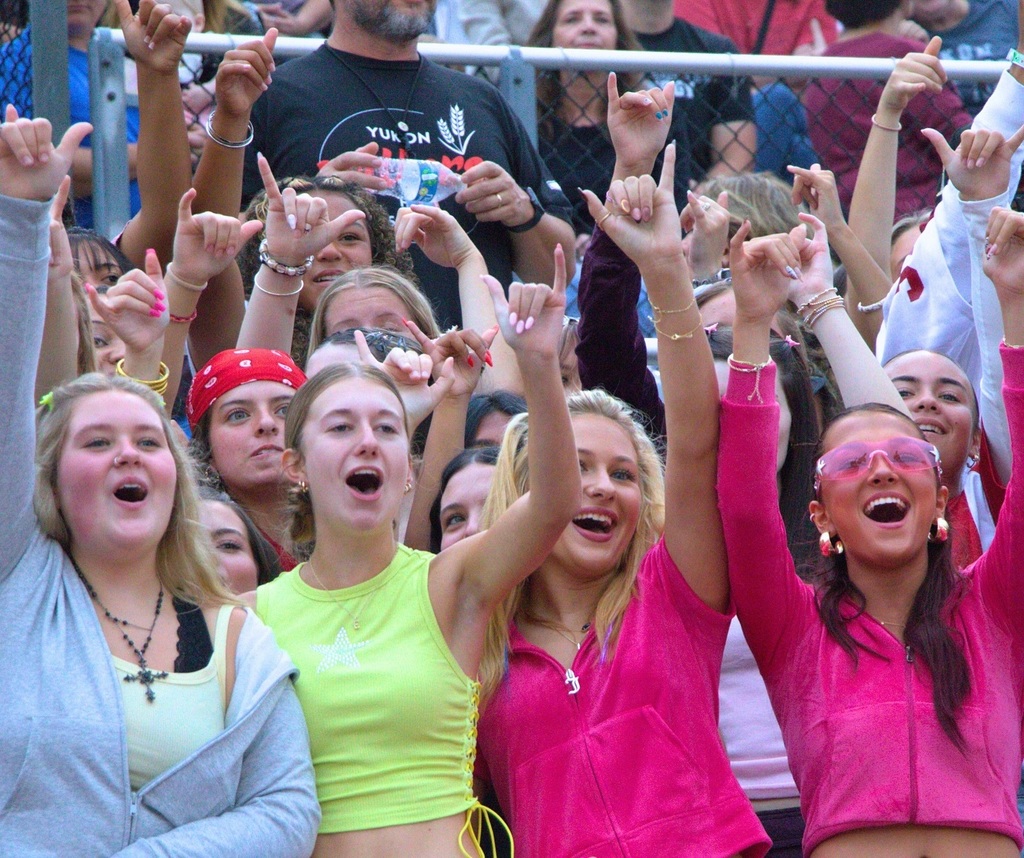 Students cheering at a football game holding up their Y Millers sign